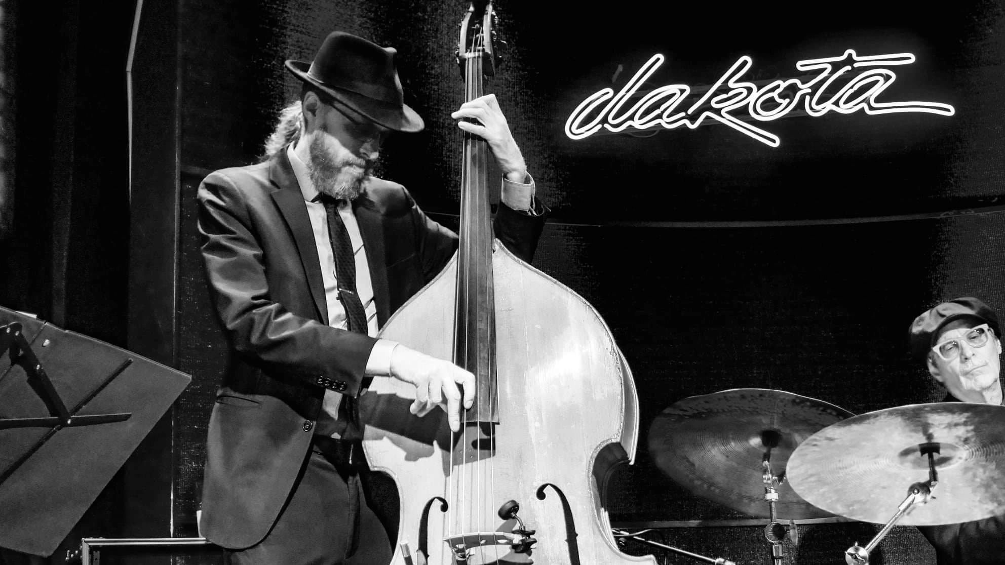 Matt Senjem on upright bass under the Dakota neon sign, black and white