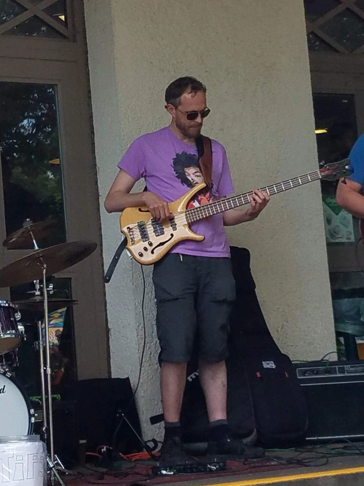Matt Senjem playing five-string electric bass at an outdoor gig