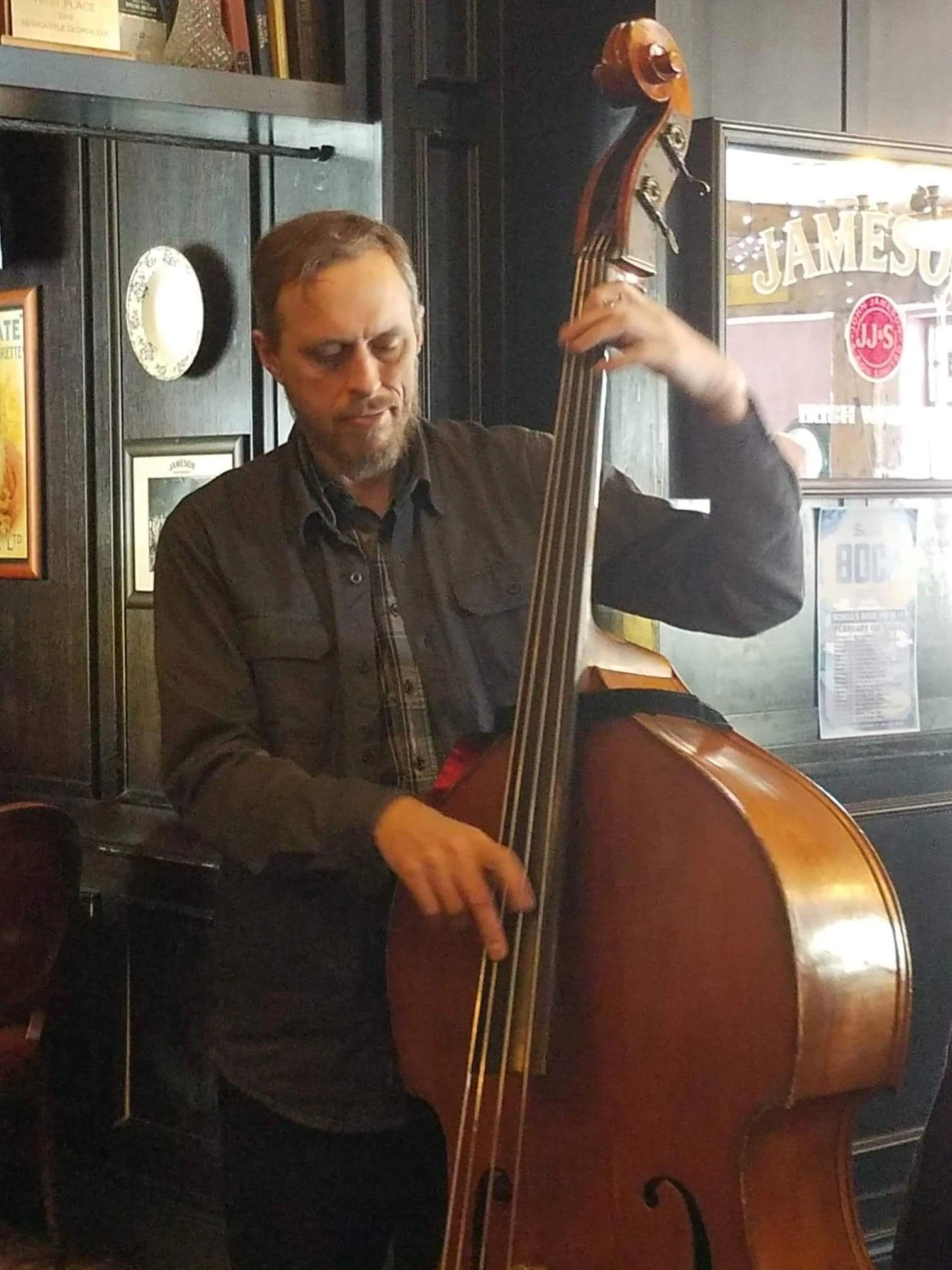 Matt Senjem playing upright bass at a pub gig